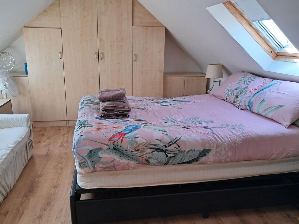 A bedroom with a bed, wardrobe, and lamp at The Lookout -The House With A View, Weymouth