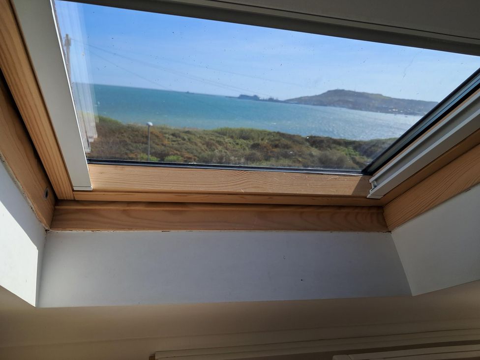 A view of the sea and hills through a skylight at The Lookout -The House With A View in Weymouth