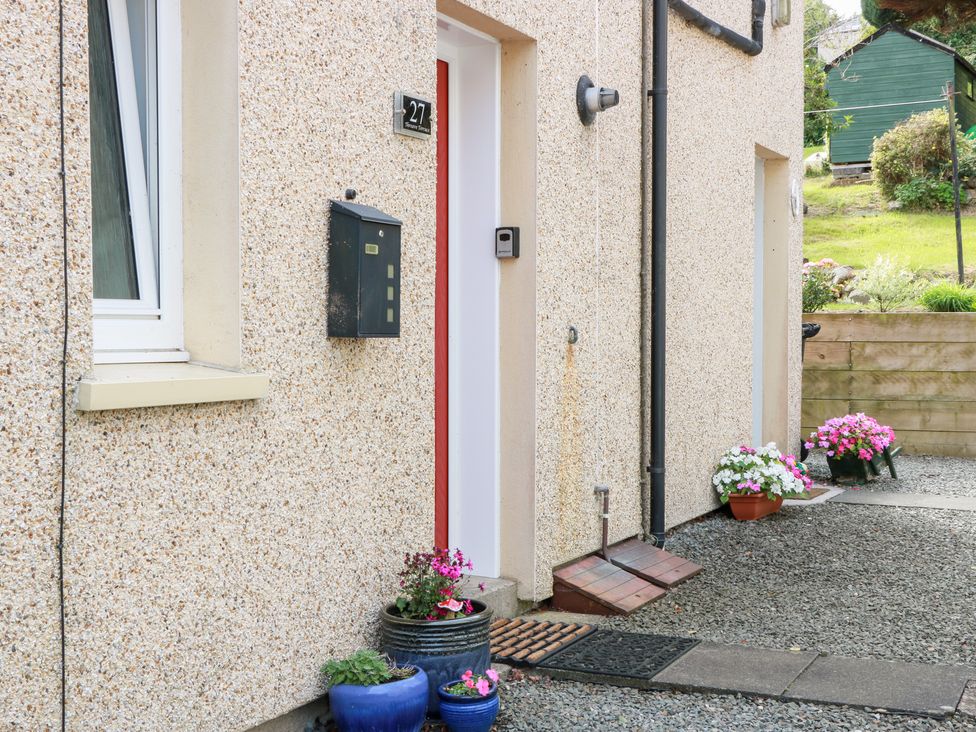 An exterior view of a house entrance with a door and flower pots at Simply Suite in Castle Douglas