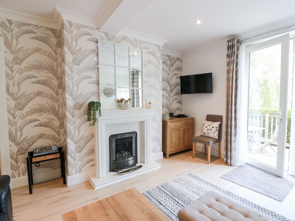 A living room with a fireplace and television at Simply Suite in Castle Douglas
