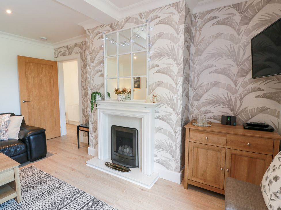 A living room with a fireplace and sofa at Simply Suite in Castle Douglas