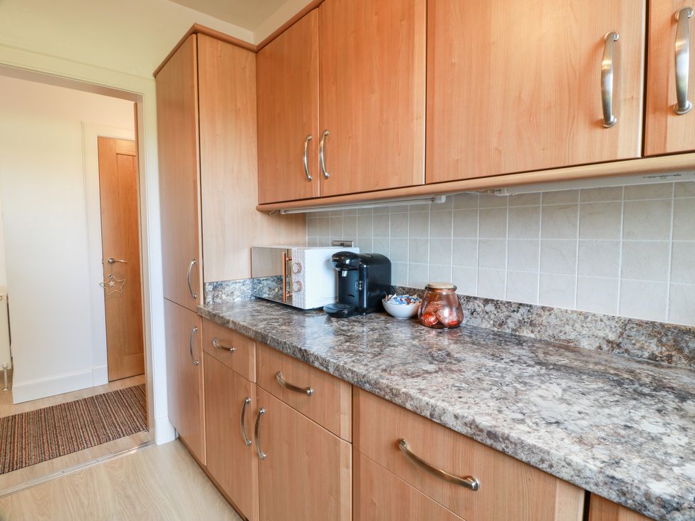 A kitchen with cabinets and a coffee maker at Simply Suite in Castle Douglas