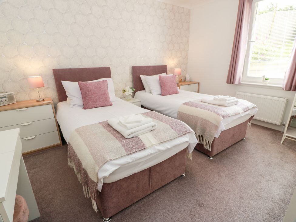 A bedroom with two single beds and a drawer at Simply Suite in Castle Douglas