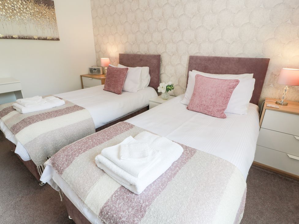 A bedroom with two beds and a nightstand at Simply Suite in Castle Douglas