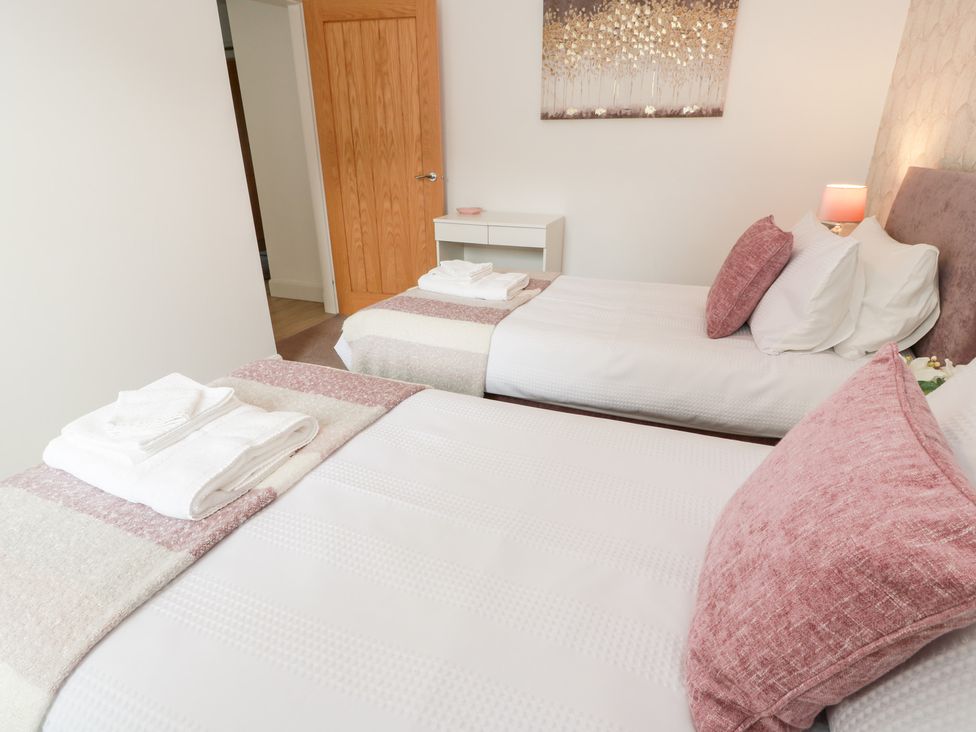 A bedroom with two beds and a nightstand at Simply Suite in Castle Douglas