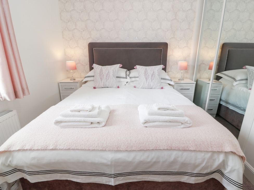 A bedroom with a bed and bedside lamp at Simply Suite in Castle Douglas
