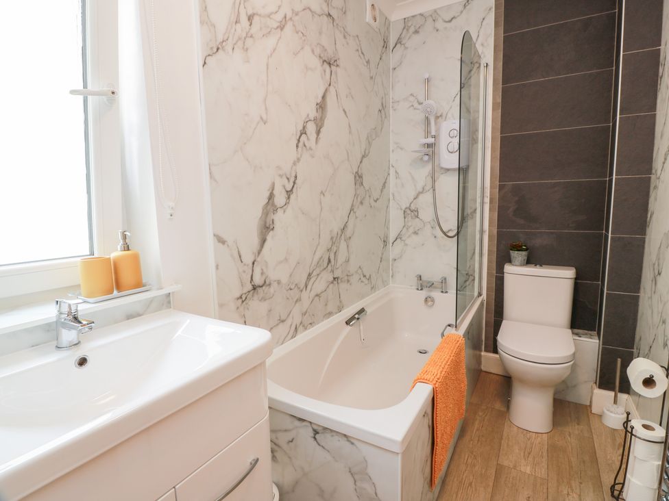 A bathroom with a bathtub and toilet at Simply Suite, Castle Douglas