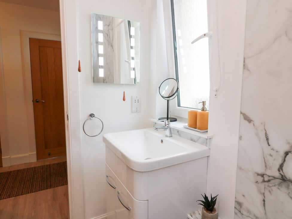 A bathroom with a sink and mirror at Simply Suite in Castle Douglas