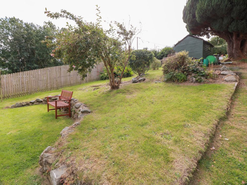 A garden with a bench and a shed at Simply Suite in Castle Douglas