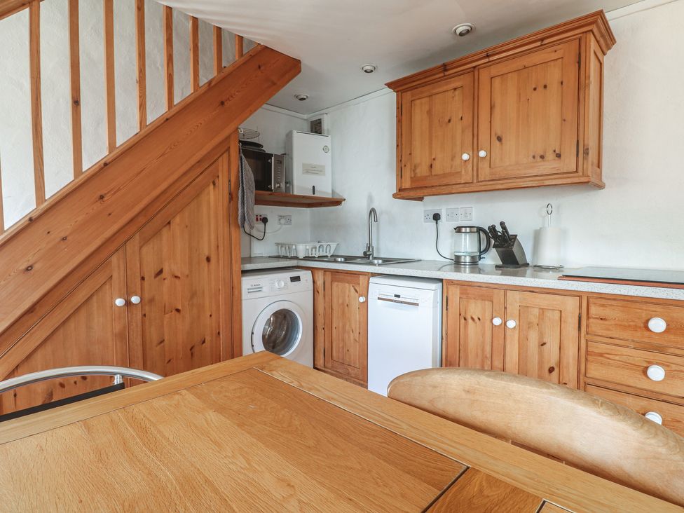 A kitchen with wooden cabinets and appliances at Kernyk in Penzance