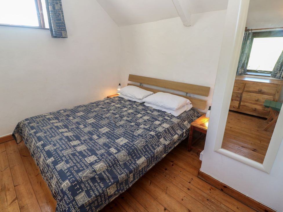 A bedroom with a bed and nightstand at Kernyk in Penzance