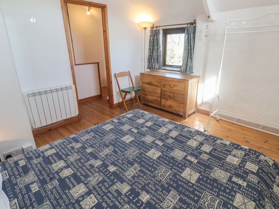 A bedroom with a bed, chest of drawers and a window at Kernyk in Penzance