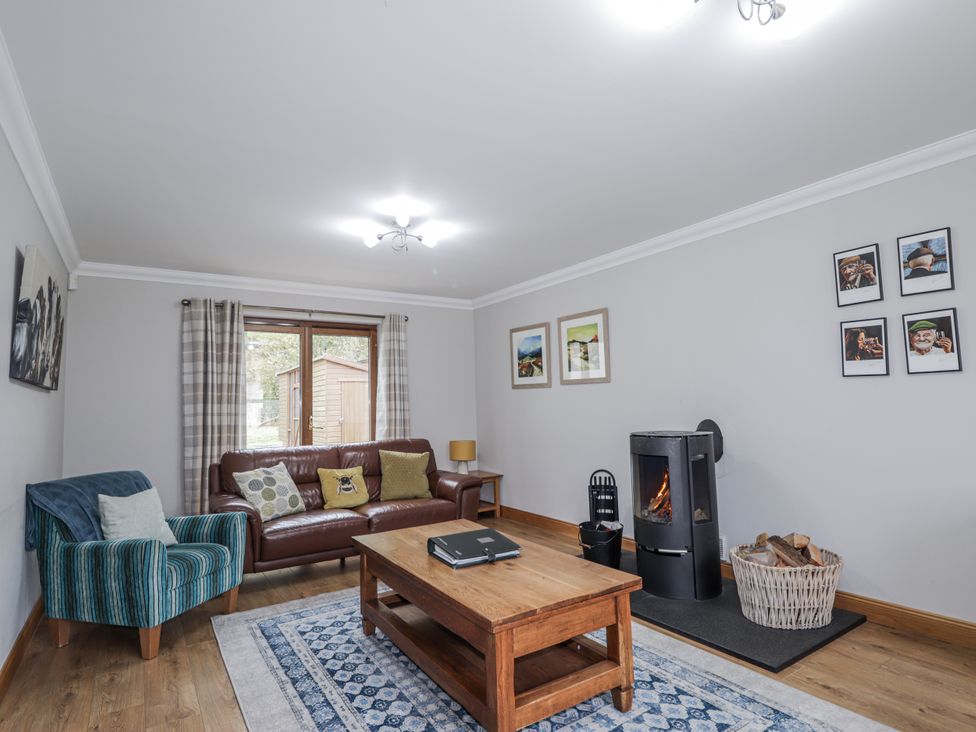 A living room with a sofa and fireplace at Burnside House in Aviemore