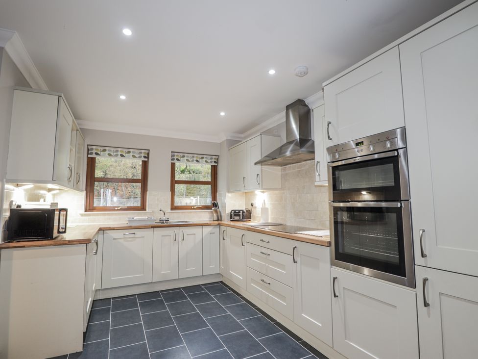 A kitchen with cabinets and appliances at Burnside House in Aviemore