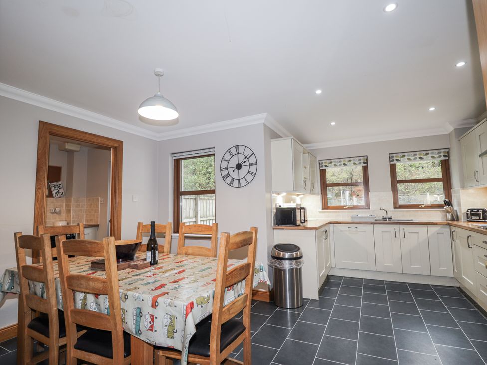 A kitchen with a dining table and chairs at Burnside House in Aviemore