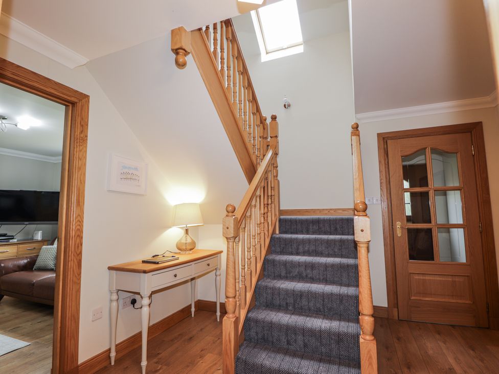 An entryway with a staircase and console table at Burnside House in Aviemore