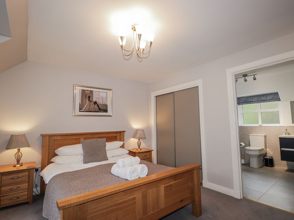 A bedroom with a bed and ensuite bathroom at Burnside House in Aviemore