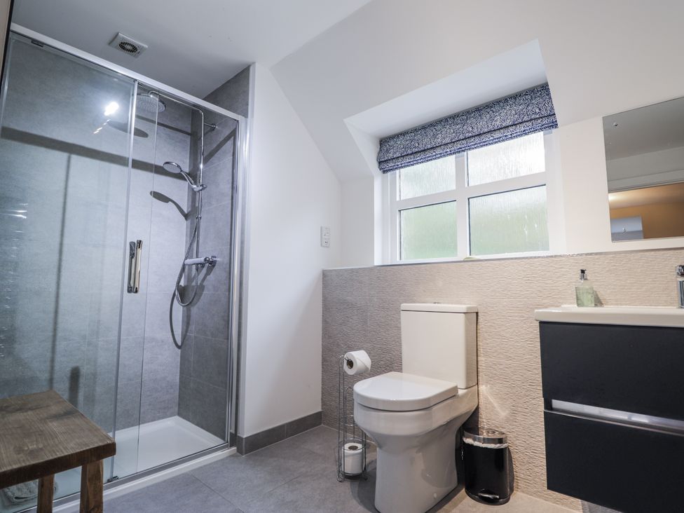 A bathroom with a shower, toilet, and washbasin at Burnside House in Aviemore