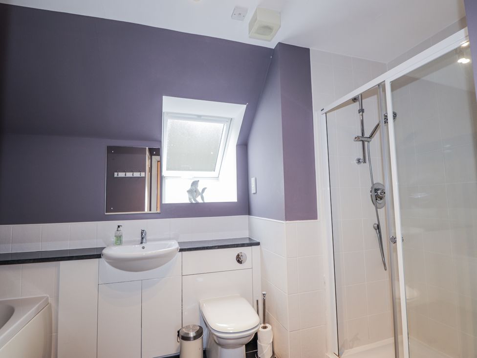 A bathroom with a sink, toilet, and shower at Burnside House in Aviemore