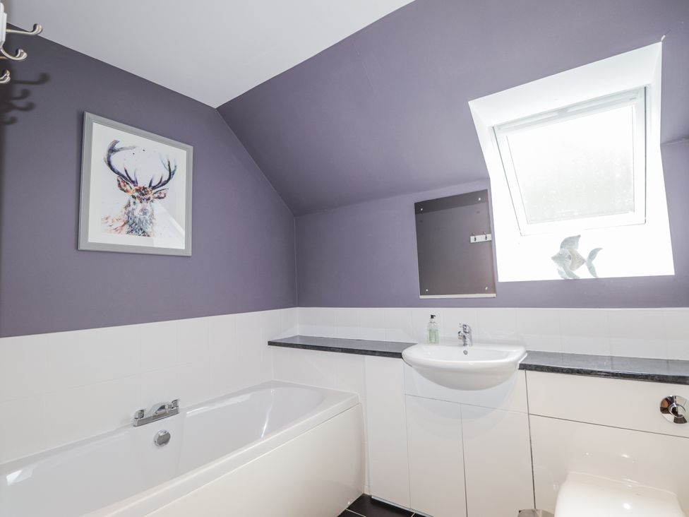 A bathroom with a bathtub and sink at Burnside House, Aviemore