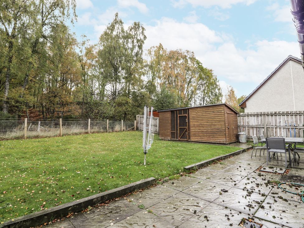 A garden with a wooden shed and patio at Burnside House in Aviemore