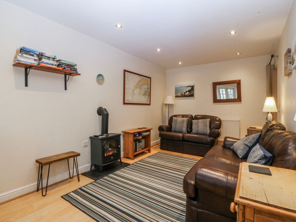 A living room with furniture and a stove at Bwthyn Llechen in Porthmadog