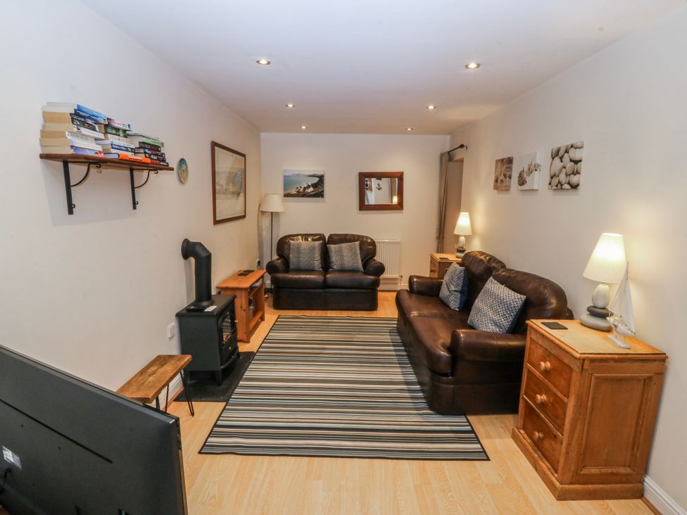 A living room with a sofa and television at Bwthyn Llechen in Porthmadog