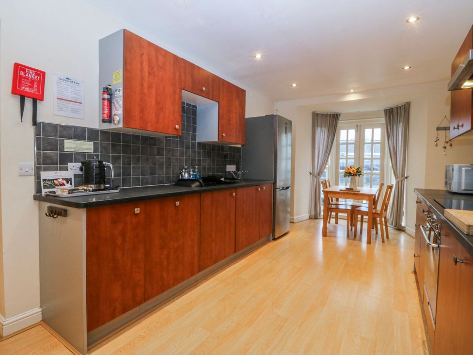A kitchen with a table and chairs at Bwthyn Llechen in Porthmadog