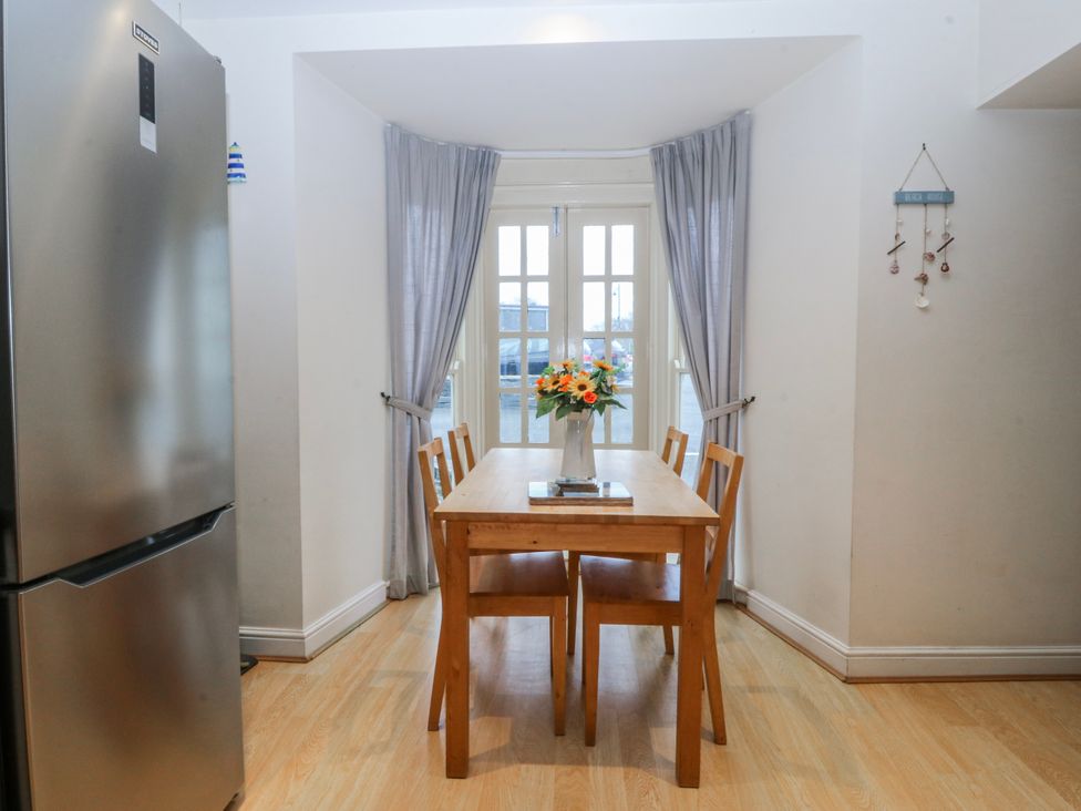 A dining room with a table and chairs at Bwthyn Llechen in Porthmadog