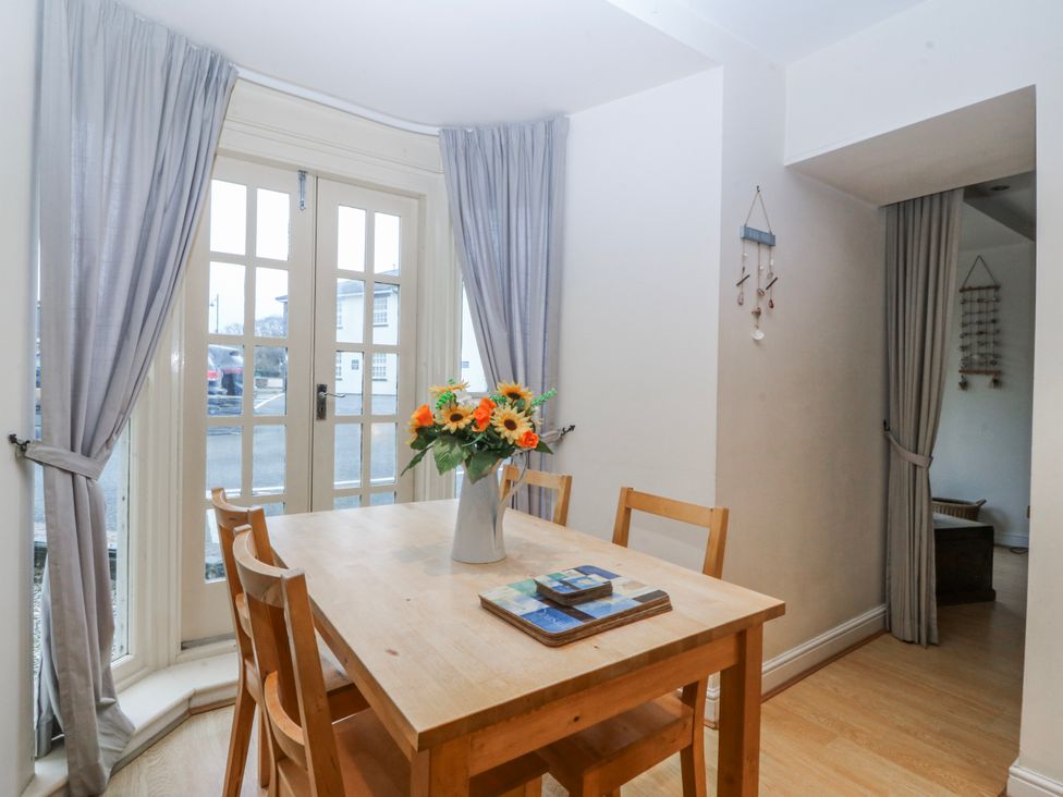 A dining room with a table and chairs at Bwthyn Llechen Porthmadog