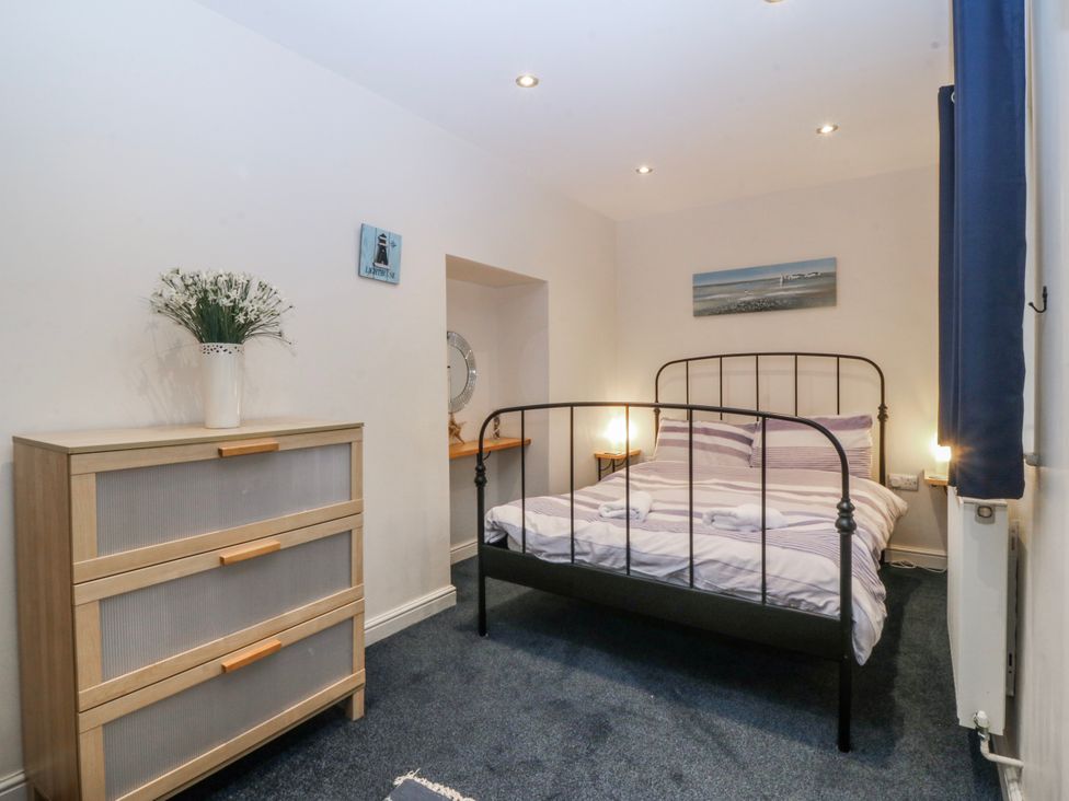 A bedroom with a bed and dresser at Bwthyn Llechen in Porthmadog