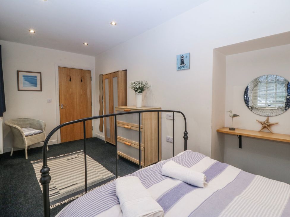 A bedroom with a bed and a chest of drawers at Bwthyn Llechen in Porthmadog