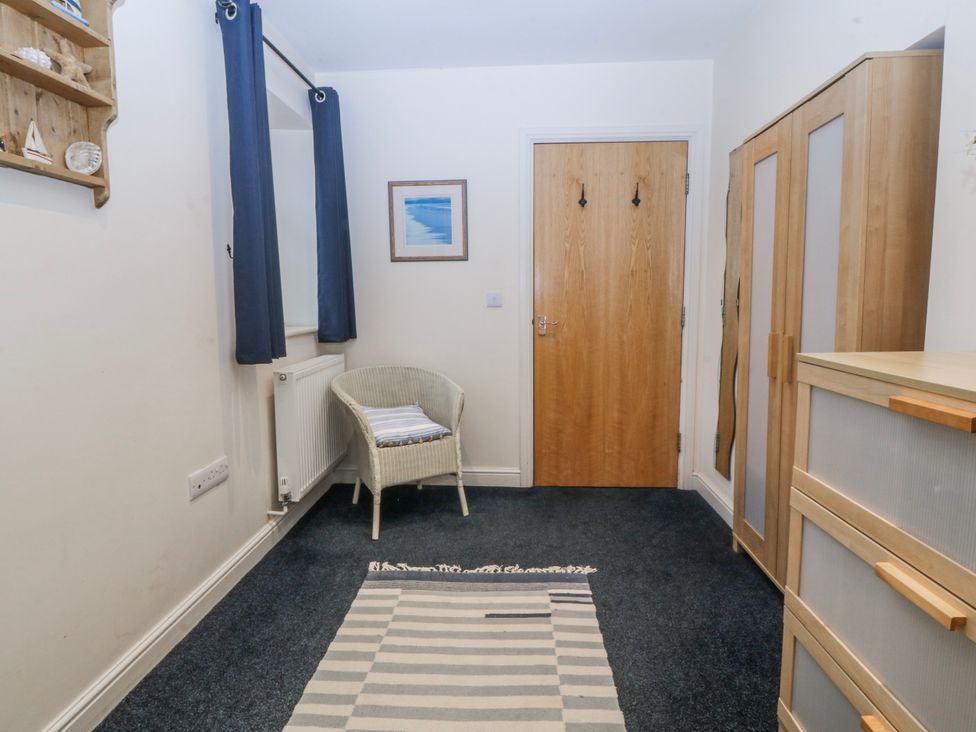 A hallway with a chair and wardrobe at Bwthyn Llechen Porthmadog