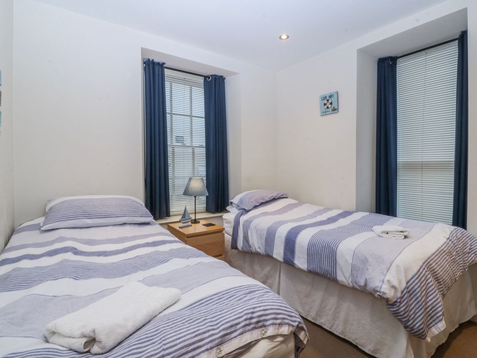 A bedroom with two beds and a lamp at Bwthyn Llechen in Porthmadog