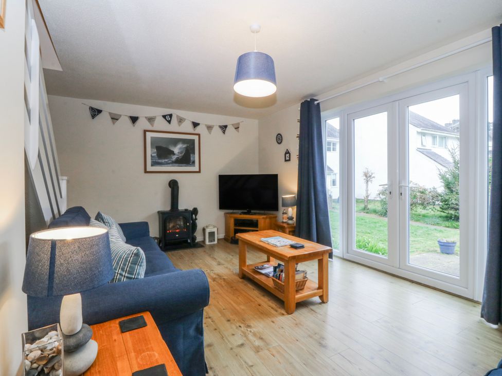 A living room with a sofa and a television at Bwthyn y Mor in Borth-y-Gest near Porthmadog