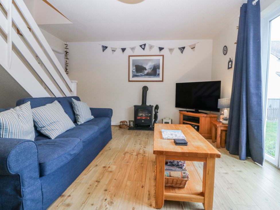 A living room with a sofa and coffee table at Bwthyn y Mor Borth-y-Gest near Porthmadog