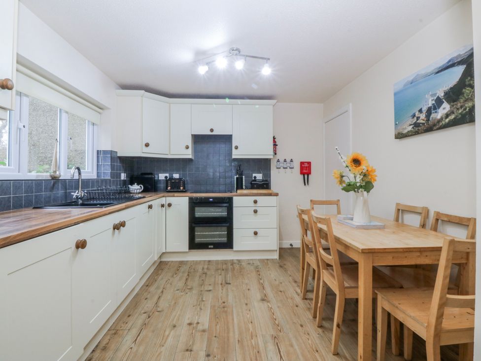 A kitchen with a wooden table and chairs at Bwthyn y Mor in Borth-y-Gest near Porthmadog