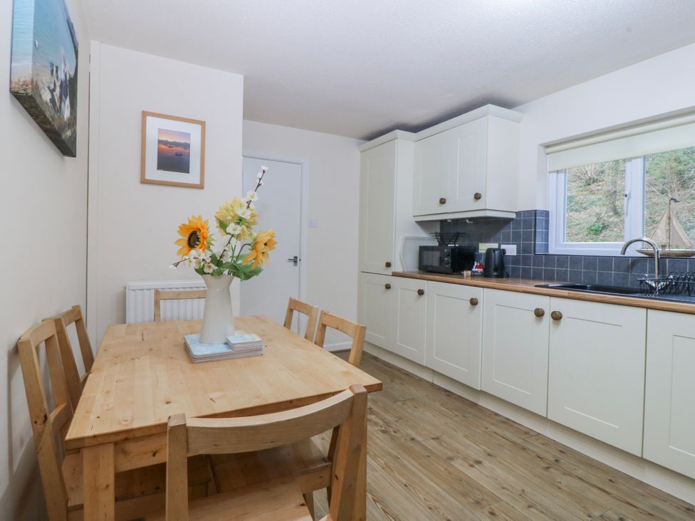 A kitchen with a wooden table and chairs at Bwthyn y Mor in Borth-y-Gest near Porthmadog