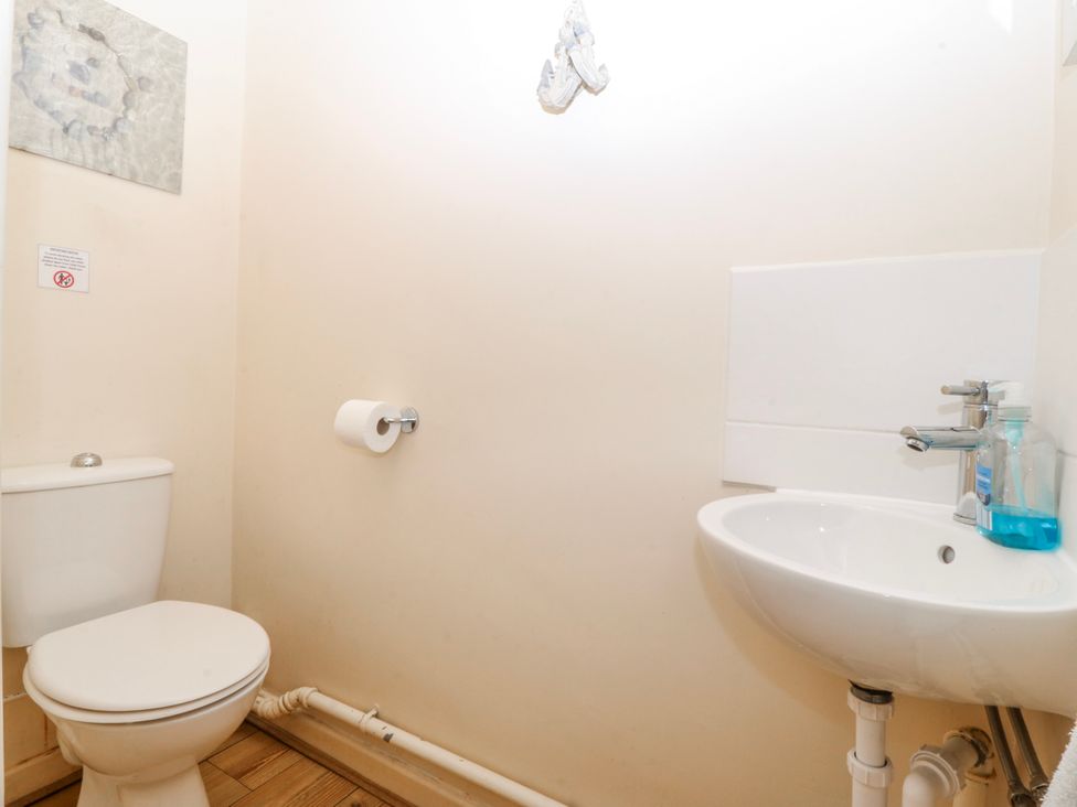 A bathroom with a toilet and sink at Bwthyn y Mor near Borth-y-Gest