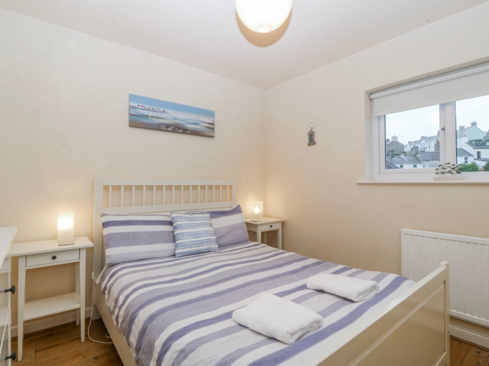 A bedroom with a bed and bedside tables at Bwthyn y Mor in Borth-y-Gest near Porthmadog