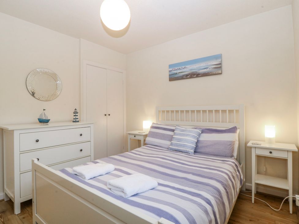 A bedroom with a bed and bedside tables at Bwthyn y Mor Borth-y-Gest near Porthmadog