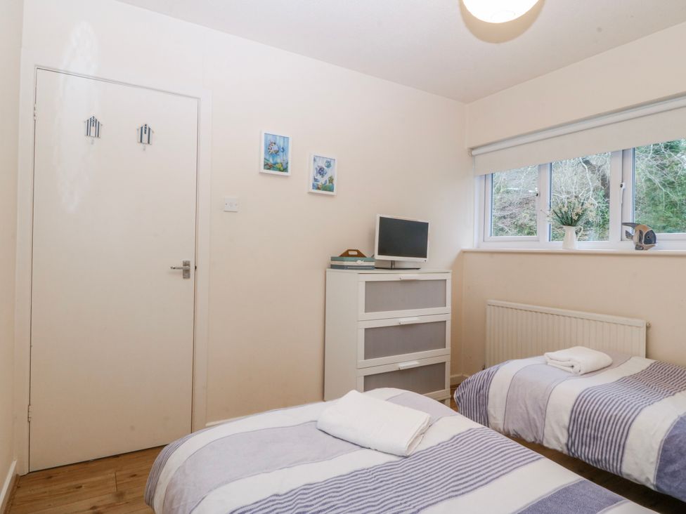 A bedroom with two beds and a television at Bwthyn y Mor in Borth-y-Gest near Porthmadog