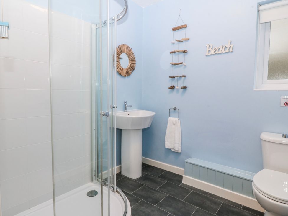 A bathroom with a shower and sink at Bwthyn y Mor in Borth-y-Gest near Porthmadog