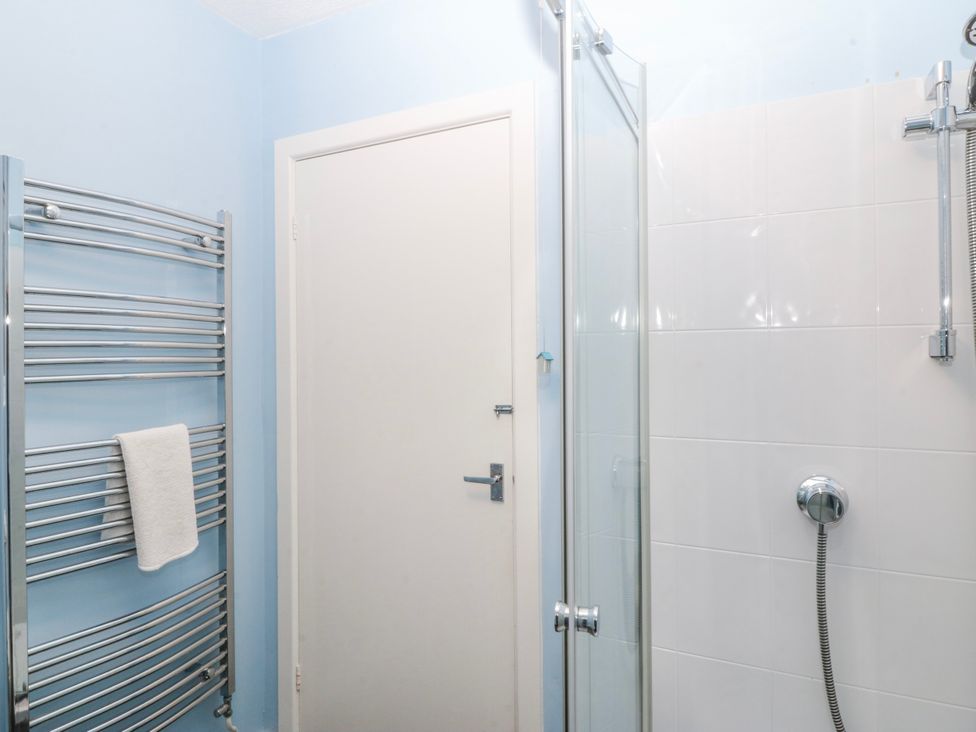 A bathroom with a shower and towel rail at Bwthyn y Mor in Borth-y-Gest near Porthmadog