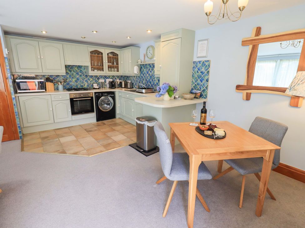 A kitchen with appliances and dining table at Lakeside Cottage Ecclerigg near Ambleside