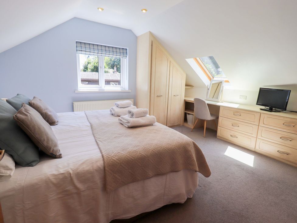 A bedroom with a bed and desk at Lakeside Cottage in Ecclerigg near Ambleside