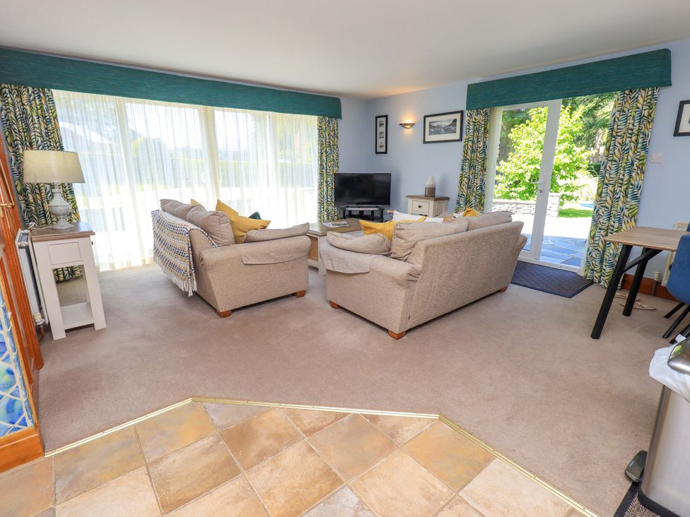 A living room with two sofas and a television at Waterhead Cottage in Ecclerigg, near Troutbeck Bridge