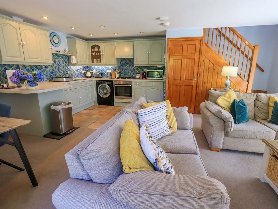 A living room with a kitchen area and seating at Waterhead Cottage in Ecclerigg, near Troutbeck Bridge