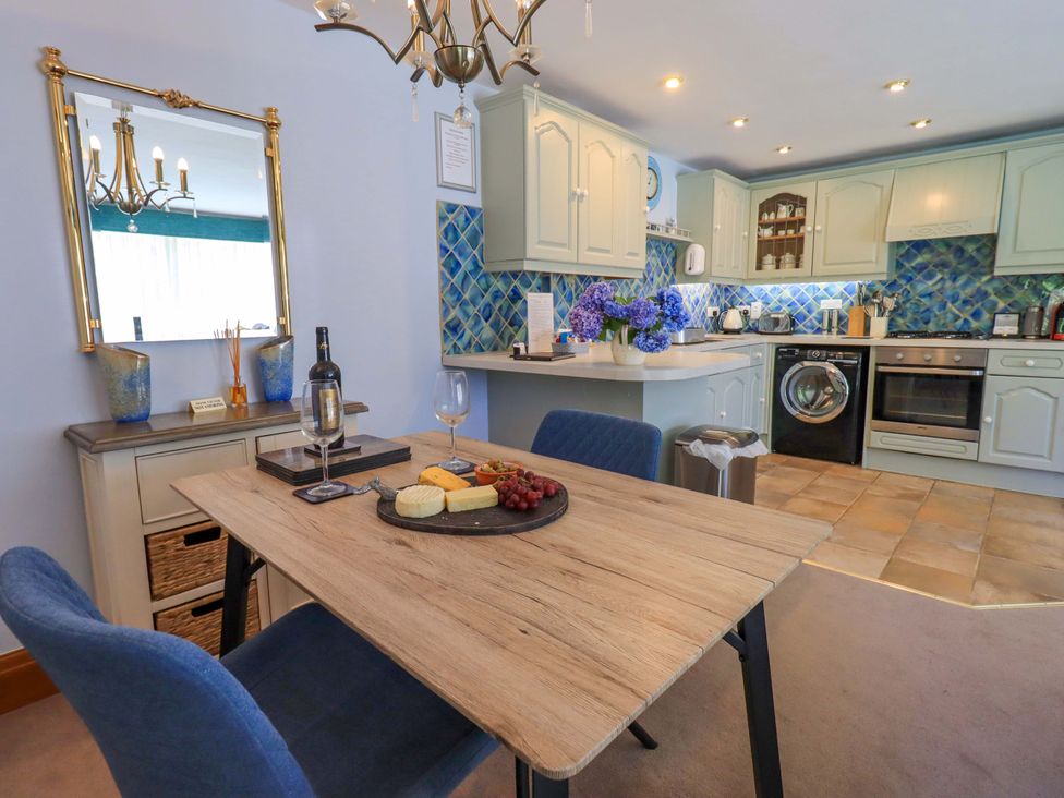 A kitchen with a dining area featuring a table and chairs at Waterhead Cottage, Ecclerigg, near Troutbeck Bridge