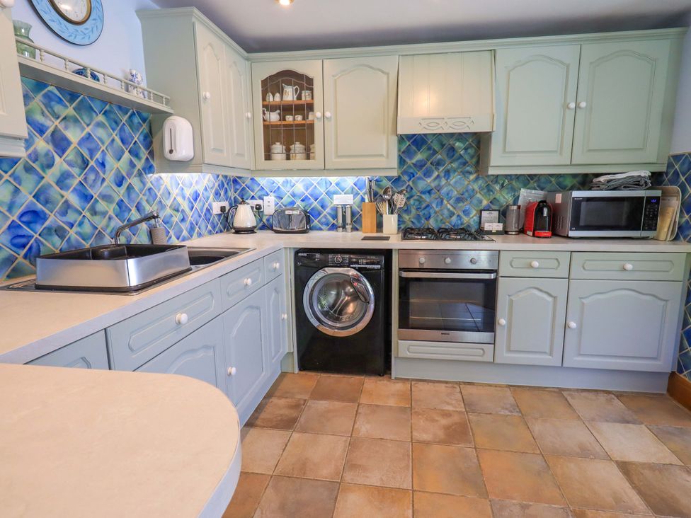A kitchen with appliances and cabinets at Waterhead Cottage near Ecclerigg, near Troutbeck Bridge
